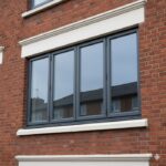 Anthracite grey uPVC 4-section loggia glazing installed on Dublin apartment building — Dublin Blinds